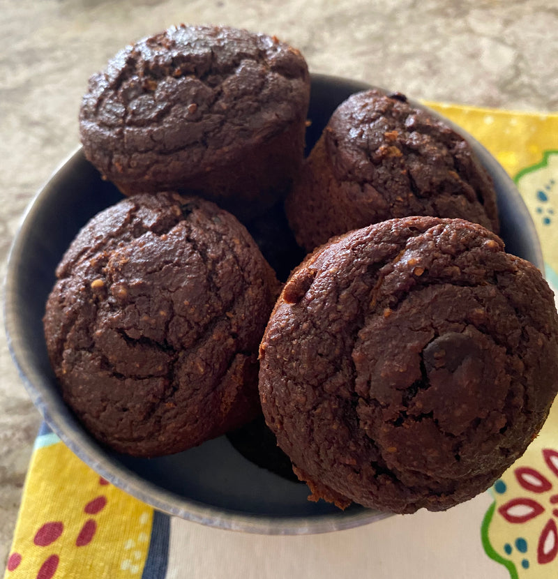Moist and fluffy zucchini double chocolate muffins nestled in a ceramic bowl.